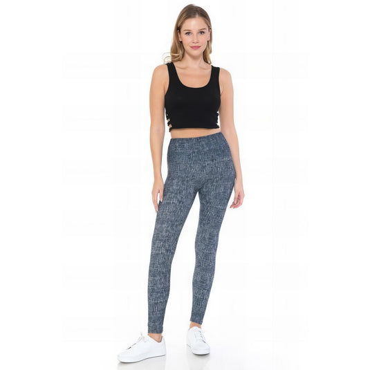 Woman wearing high-waist yoga leggings featuring a chic blue multi-print pattern, paired with a black crop top for a stylish fitness look.