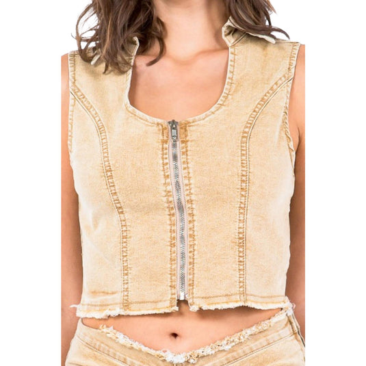 Close-up image of a beige cropped denim vest with a front zipper and frayed hem detailing, showcasing the structured seams and raw finish.