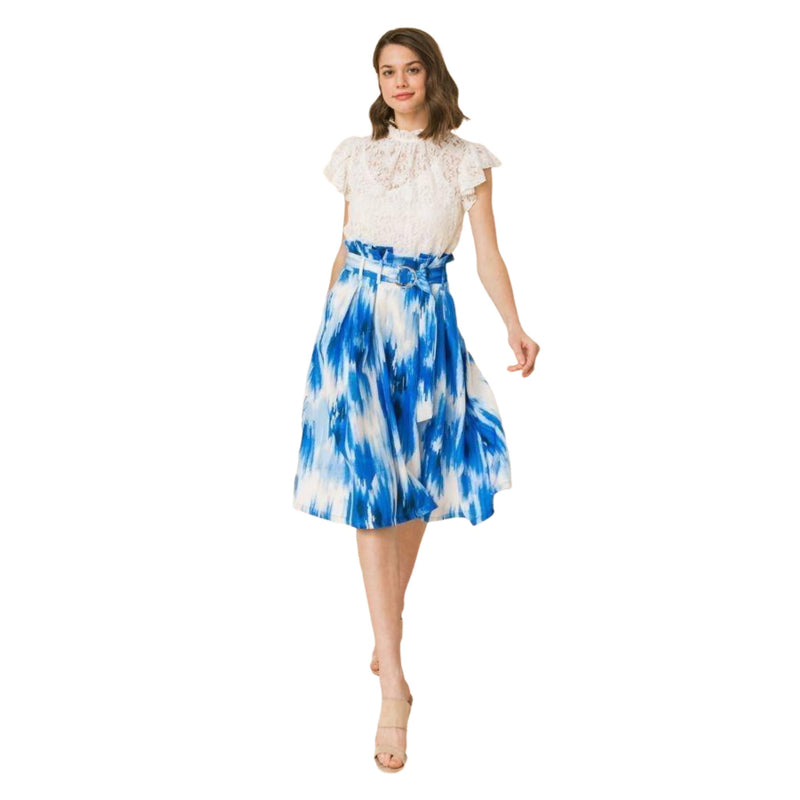 Load image into Gallery viewer, Elegant woman in a chic lace top and tie-dye blue midi skirt ensemble, complemented with beige high-heeled sandals, posing with one hand lightly resting on a vintage piano.
