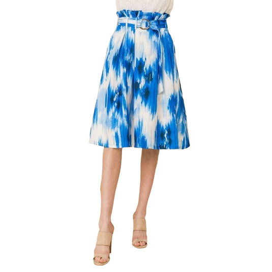 Frontal view of a stylish tie-dye blue and white pleated midi skirt with a fashionable paper bag waist and a coordinating belt, paired with a delicate white lace blouse.