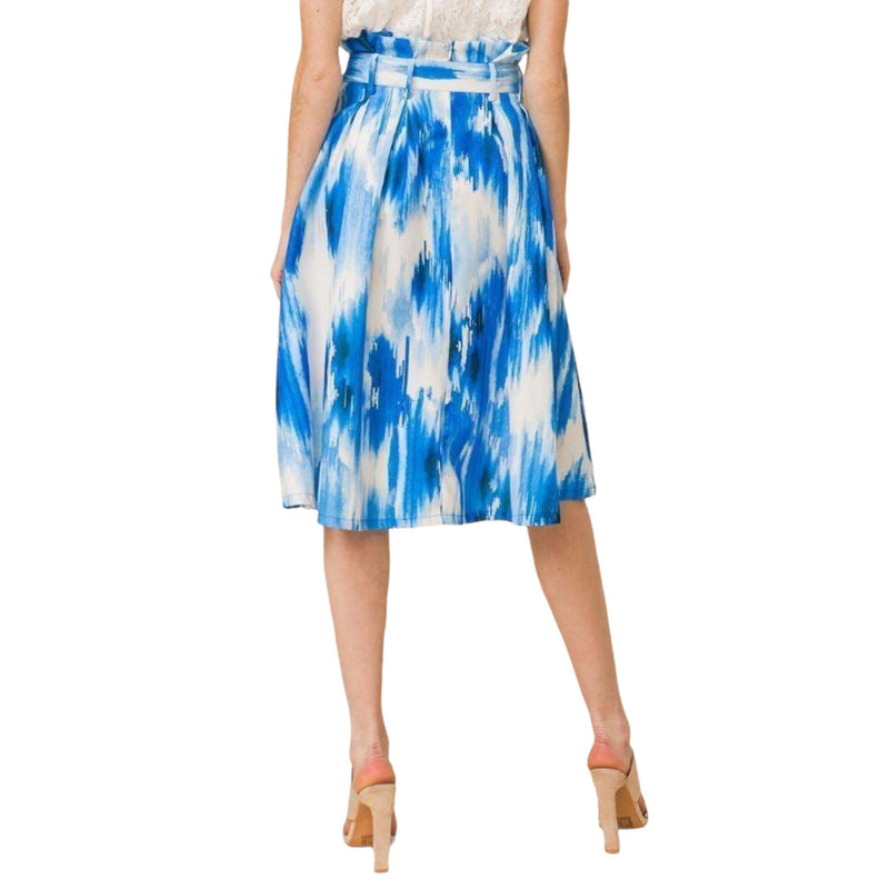 Load image into Gallery viewer, Rear view of a fashionable midi skirt featuring a tie-dye pattern in shades of blue and white, showcasing the trendy paper bag waist and fluid pleats.
