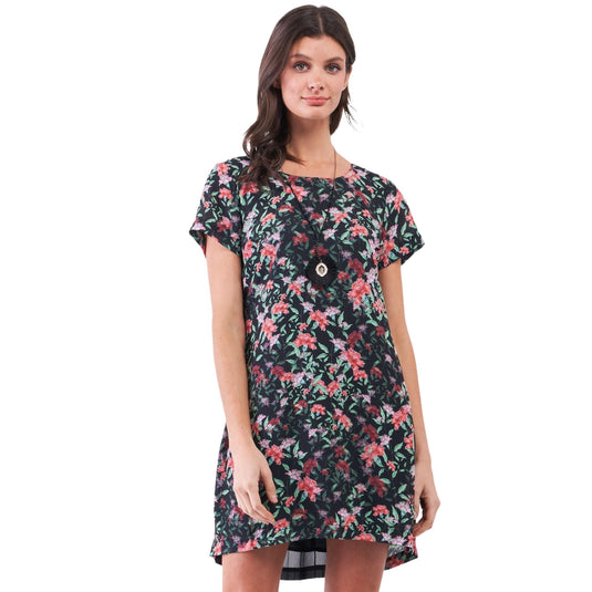 Portrait of a woman in a black mini dress with a vibrant floral pattern, featuring a round neckline and short sleeves, perfect for a casual summer day.