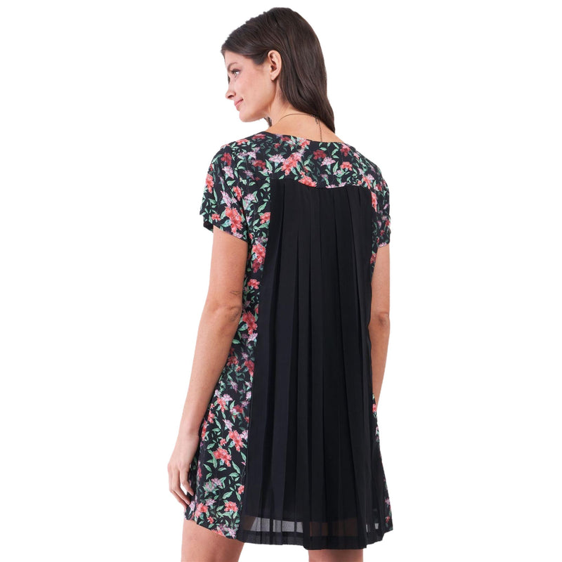 Load image into Gallery viewer, Rear view of a woman wearing a black floral mini dress with an elegantly pleated back panel, highlighting the dress&#39;s unique design and floaty silhouette.
