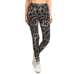 Front view of black and white music note print yoga leggings, paired with white sneakers, showcasing a high-waisted fit and vibrant design for the musically-inspired fashion enthusiast.