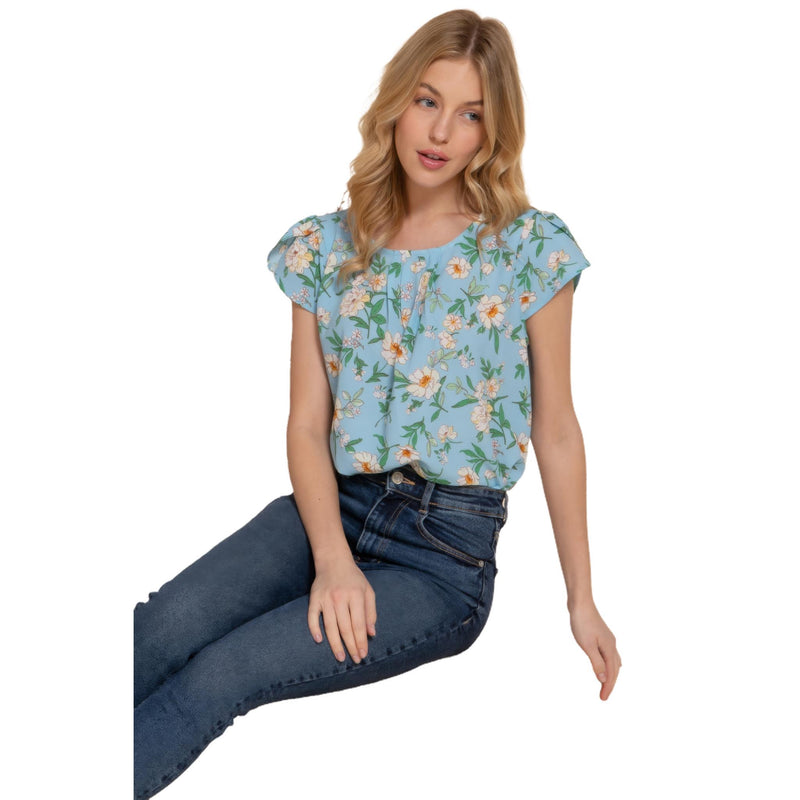 Load image into Gallery viewer, Stylish light blue floral top with a tulip sleeve design, paired with denim for a smart-casual look.
