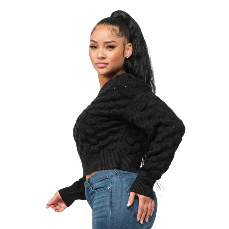 Load image into Gallery viewer, Woman posing to the side, showcasing the unique texture of her black sweater with a puffy checker design.
