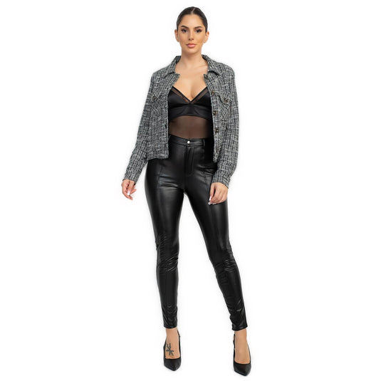 Full-length image of a model in a chic black plaid tweed jacket, styled with a black top and leather pants.