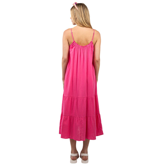 Model showing the back view of a pink cotton gauze A-line midi dress with adjustable straps and tiered design.