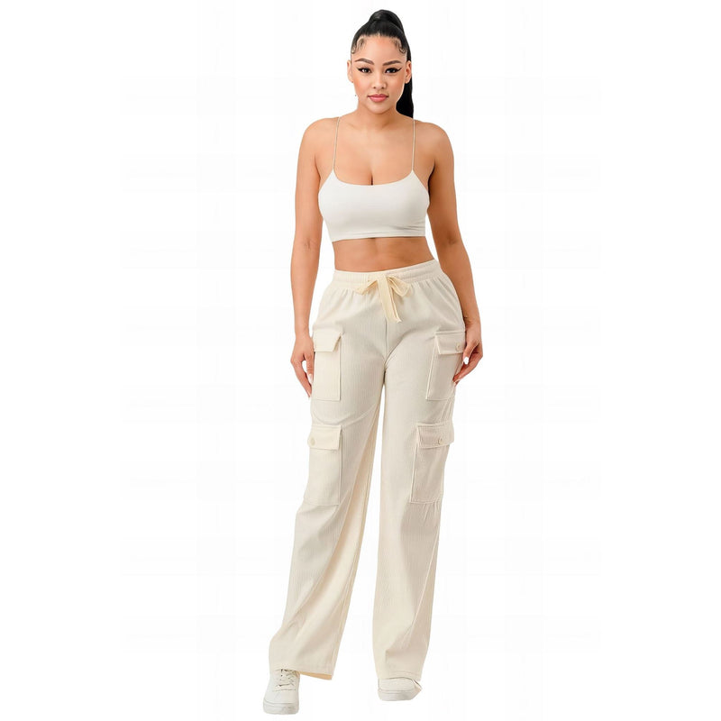 Load image into Gallery viewer, Trendsetting woman in cream corduroy cargo pants paired with a minimalist white crop top, creating a fresh and sophisticated casual look.
