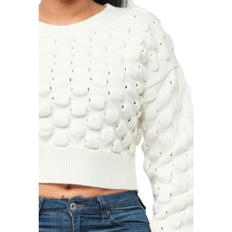 Load image into Gallery viewer, Close-up of the cream sweater&#39;s unique puffy checker texture, demonstrating the intricate pattern and cozy ribbed cuffs.
