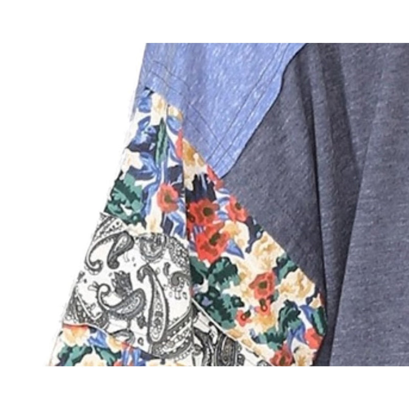 Load image into Gallery viewer, Detailed close-up of the sleeve of a denim mix floral dolman top. The sleeve features a vibrant floral pattern with a mix of blue, white, green, and orange colors.
