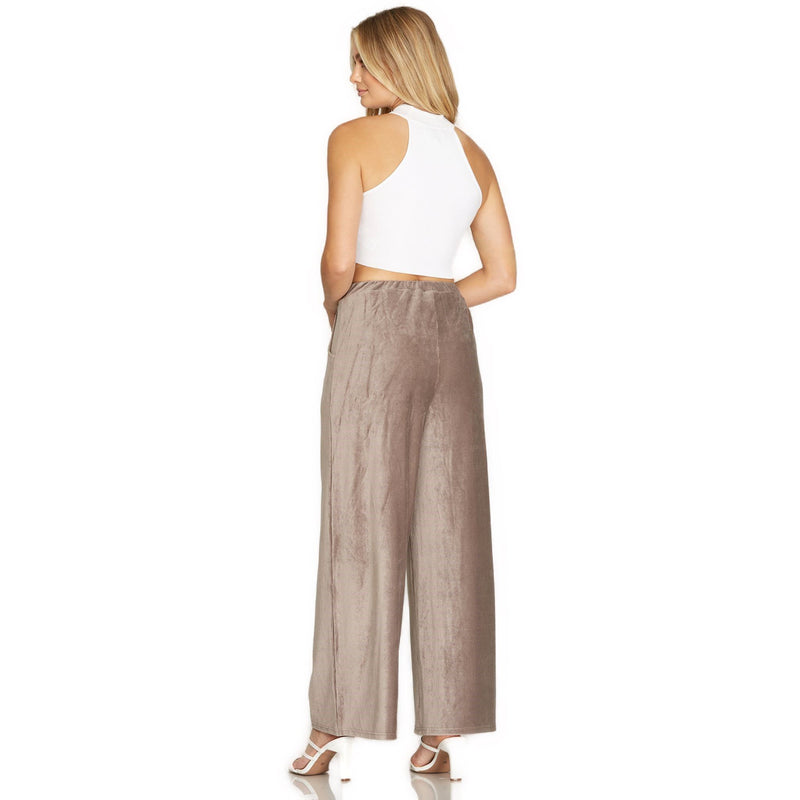 Load image into Gallery viewer, Rear view of a model in white sleeveless crop top and mocha velvet pants with a comfortable elastic waistband, showcasing a relaxed fit.
