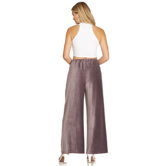 Back view of the mauve velvet wide-leg pants showing the elastic waistband and loose fit, paired with a simple white crop top for a chic look.