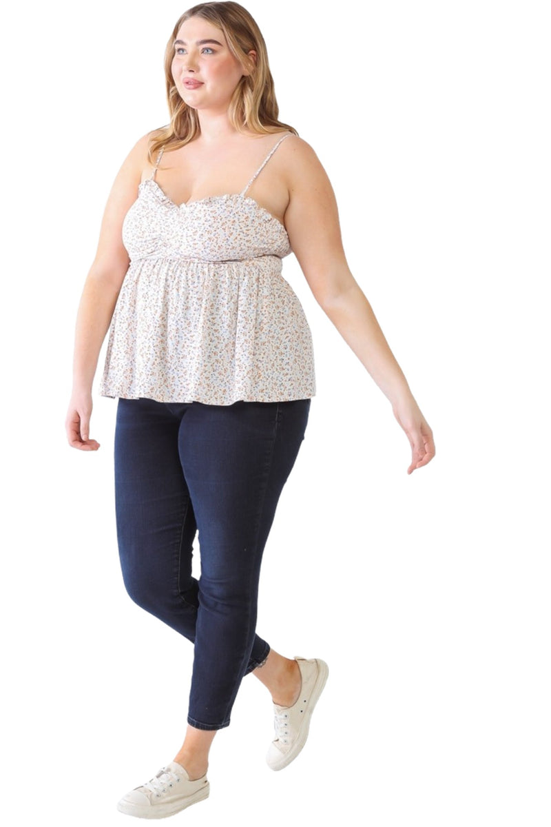 Load image into Gallery viewer, Plus-size model in a floral smocked sweetheart neck cami paired with dark skinny jeans and white sneakers, posing with a relaxed stride.
