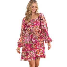 Happy woman smiling in a dark pink floral square neckline mini dress with long sleeves and a tiered hem, perfect for spring.
