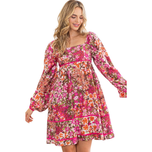 A carefree and stylish lady in a floral mini dress with a square neckline, showcasing the dress's playful pattern and flowing sleeves.