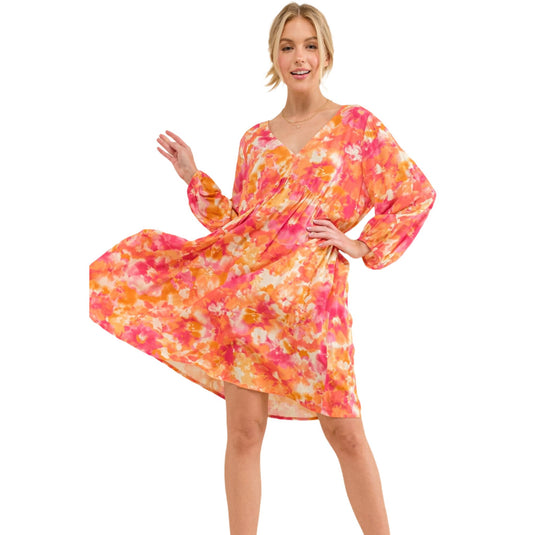 Model in a colorful floral dress, featuring a V-neck and flowy design, ideal for spring and summer fashion.