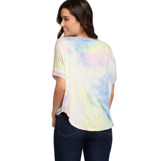 Back view of a woman wearing a yellow tie-dye top with a distinctive V-neck and drop shoulder design, reflecting a laid-back yet fashionable style.