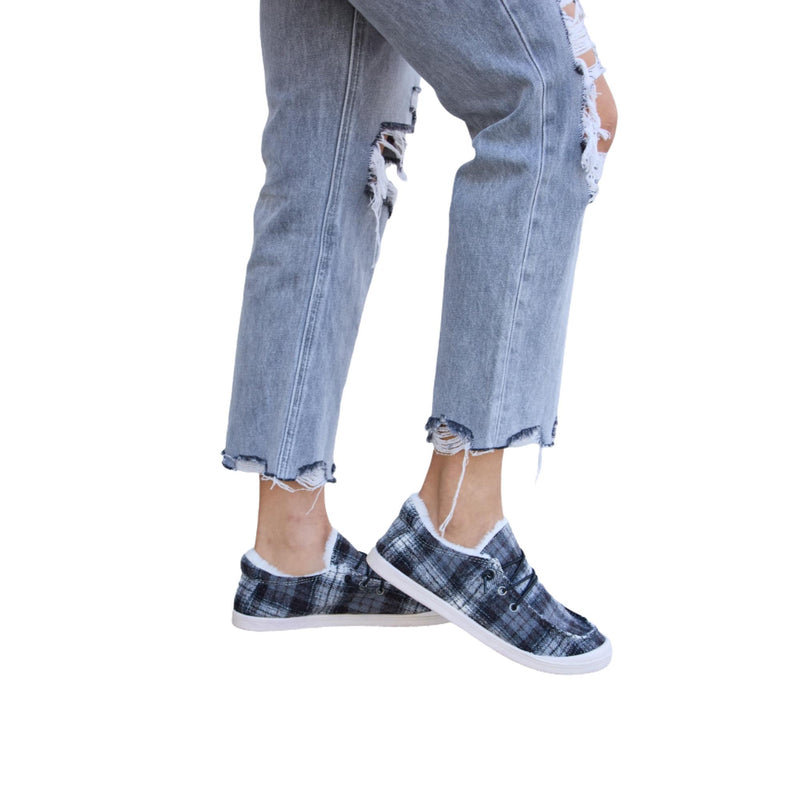 Load image into Gallery viewer, A side angle showing the plaid sneakers and distressed jeans with raw hems.
