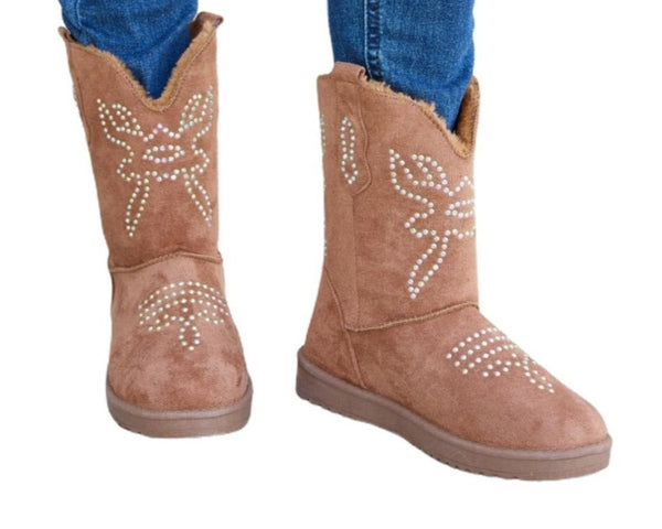 Woman wearing brown rhinestone-embellished furry flat boots with ripped skinny jeans.