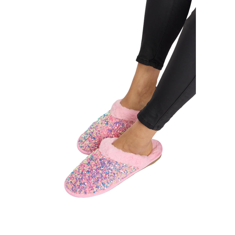 Load image into Gallery viewer, Side view of pink sequin plush slippers, worn with black leggings, highlighting the comfortable fit and soft, plush material.
