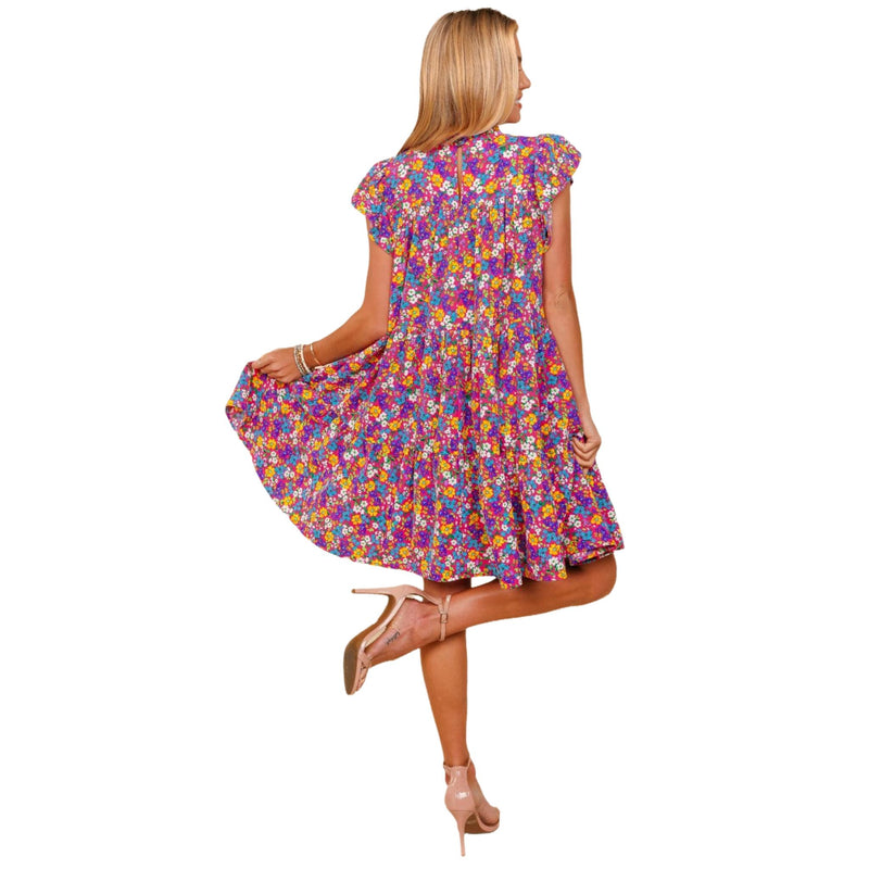 Load image into Gallery viewer, Back view of a woman wearing a frilled mock neck ditsy floral dress, highlighting the flowing skirt and back details.
