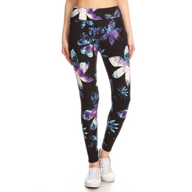 A model wears high-waisted leggings adorned with a cosmic butterfly print in hues of purple, blue, and white, paired with classic white sneakers for a casual look.