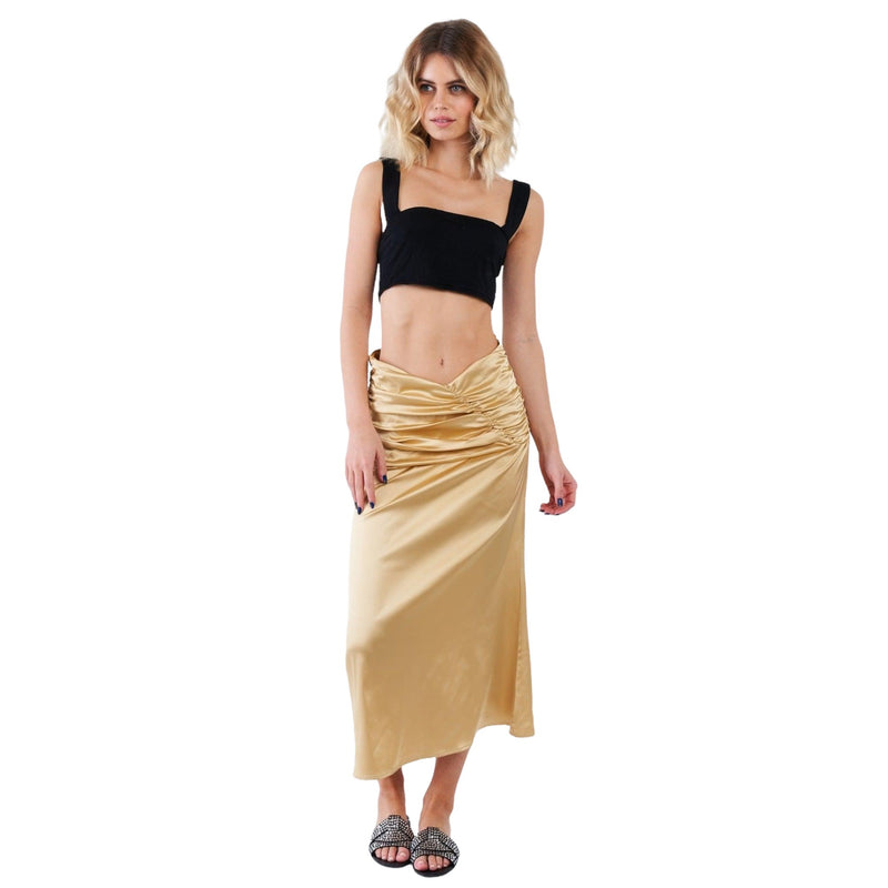 Load image into Gallery viewer, A woman wearing a golden satin ruched midi skirt paired with a cropped black tank top, standing confidently. The outfit combination suggests versatility, being suitable for both day and evening wear.
