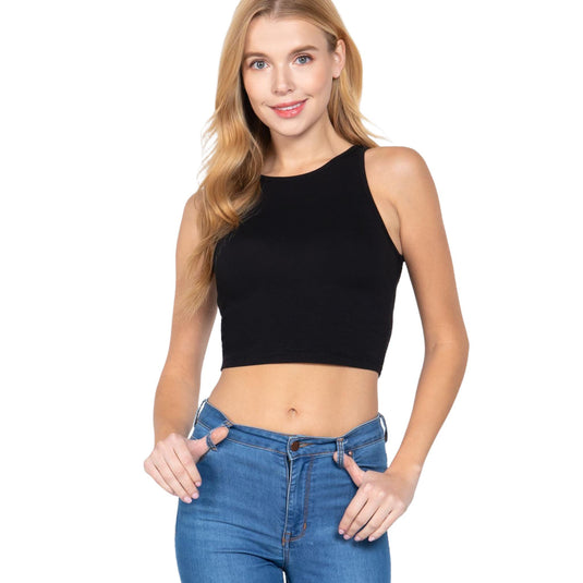 The photo presents a woman in a sleeveless black crop top with blue jeans. The top features a high neckline and a snug fit, creating a sleek and sophisticated appearance.