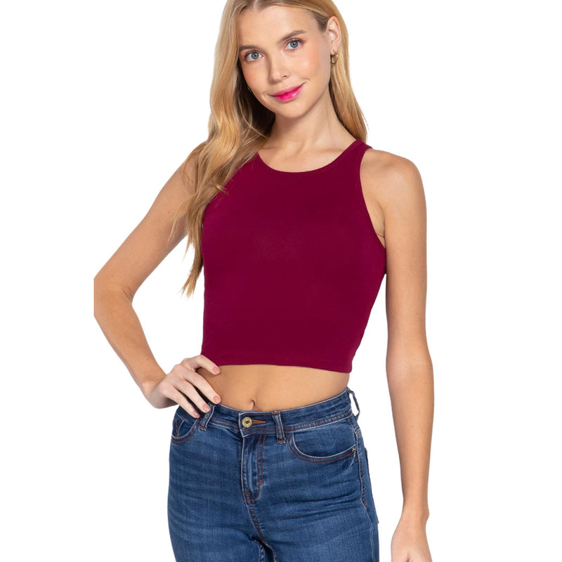 Load image into Gallery viewer, Confident woman showcasing a burgundy halter neck crop top, paired with classic blue jeans for a stylish casual look.
