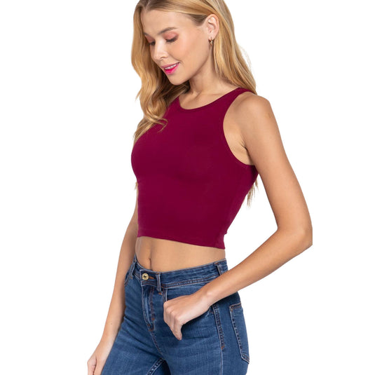 Close-up of a model in a burgundy crop top, demonstrating the top's fit and the versatility of pairing with high-waisted denim.