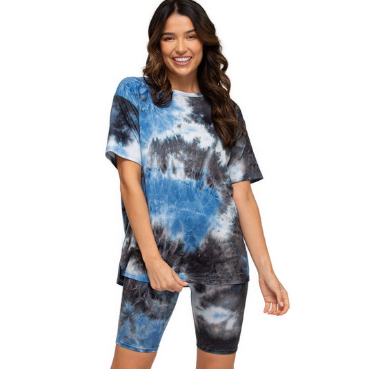 Smiling woman dressed in high-rise biker shorts featuring a stormy blue and grey tie-dye design, paired with a matching oversized tee.