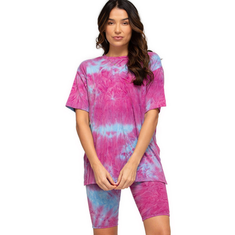 Load image into Gallery viewer, Woman wearing pink and blue tie-dye high-rise biker shorts and a coordinating oversized tee, standing with a playful stance.
