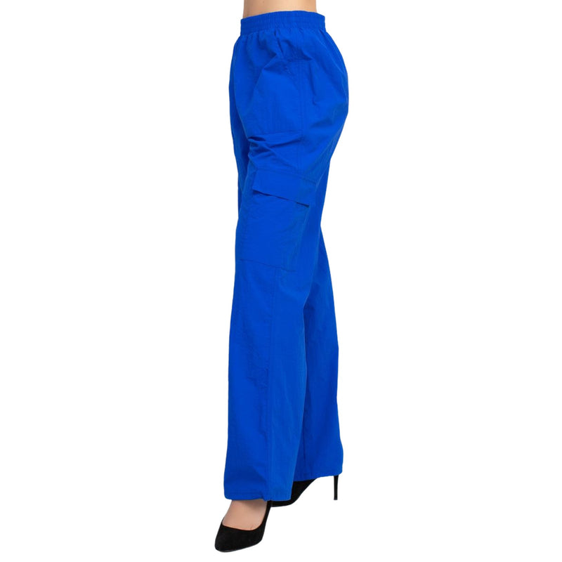 Load image into Gallery viewer, Side view of blue high rise cargo parachute pants, highlighting the cargo pocket on the side.
