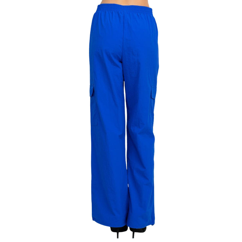 Load image into Gallery viewer, Back view of blue high rise cargo parachute pants, demonstrating the full length and relaxed fit.
