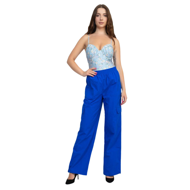 Load image into Gallery viewer, Woman wearing blue high rise cargo parachute pants with a floral bodysuit, posing confidently with one hand on her hip.
