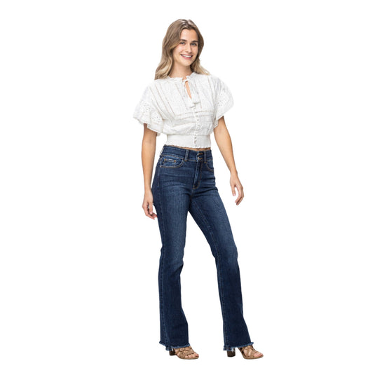 Model wearing Judy Blue Full Size Frayed Hem Bootcut Jeans paired with a white top, demonstrating the stylish and versatile fit.