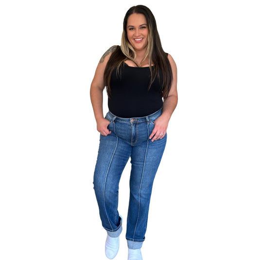 A woman smiling and posing in the High Waist Front Seam Detail Straight Jeans, paired with a black top and white sneakers for a casual yet stylish look.