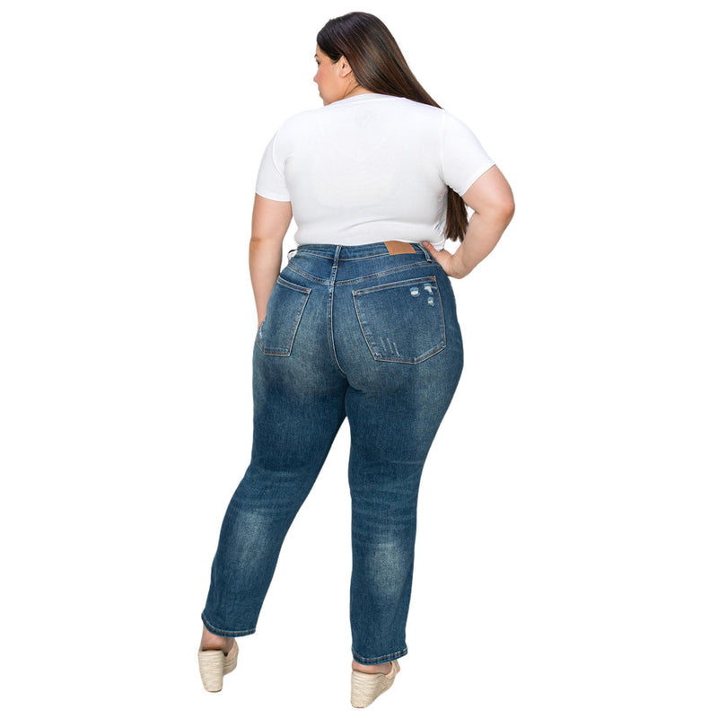 Load image into Gallery viewer, Rear view of a plus-size woman in dark wash jeans with light distressing on the pockets, showing the back fit of the jeans.
