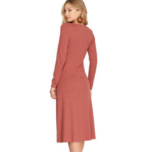 Rear view of a dusty coral colored long sleeve midi dress, emphasizing the garment's refined simplicity and the graceful flow of the skirt, ideal for a polished look.