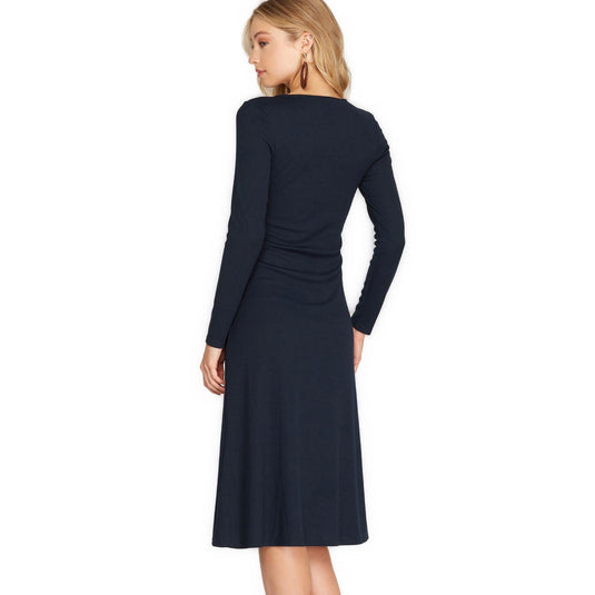 Rear perspective of a navy long sleeve midi dress with a fluid knit texture, exhibiting an elegant drape and a modest round neckline.
