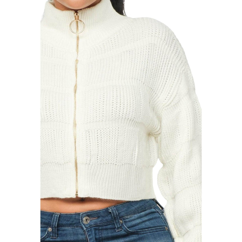 Load image into Gallery viewer, Close-up of a white knitted sweater featuring a ribbed pattern and circular zipper, emphasizing its fashionable texture.
