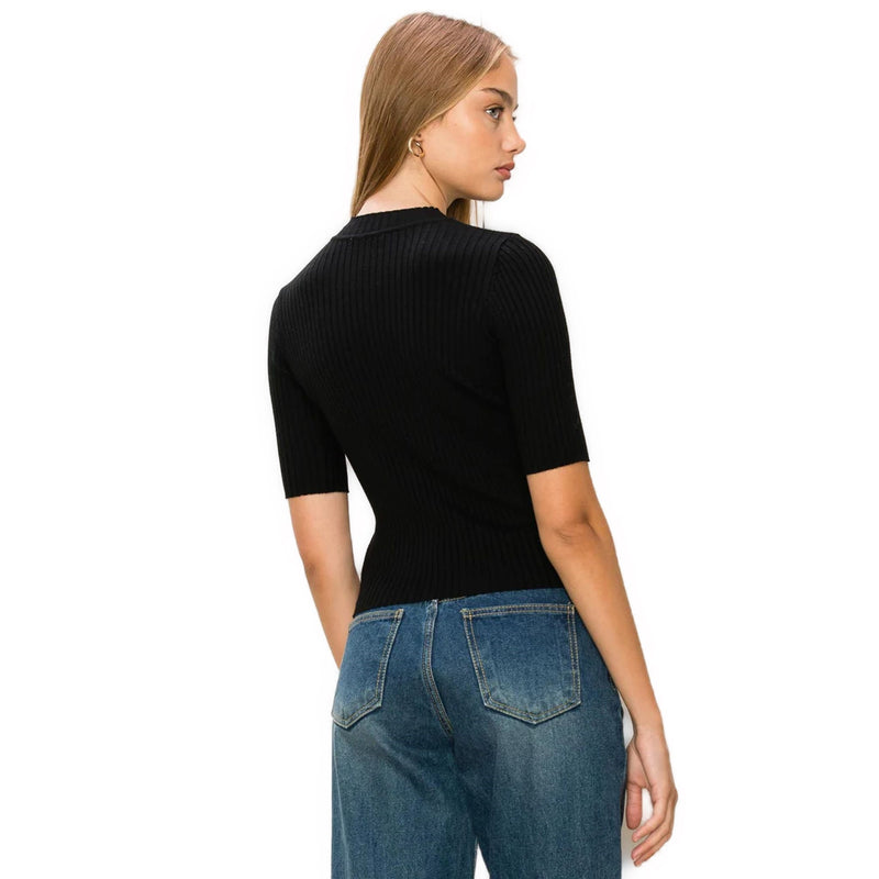 Load image into Gallery viewer, Rear angle of a woman sporting a chic black ribbed mock neck sweater, highlighting the snug fit and ribbed texture.
