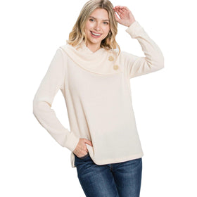 Smiling woman adjusting her beret while wearing an elegant off-white mock neck sweater, offering a cozy yet sophisticated look.