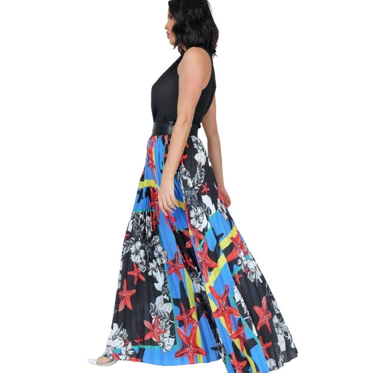 Side view of a model wearing a vibrant blue pleated maxi skirt with a black leather waistband, complemented by a tucked-in black top.