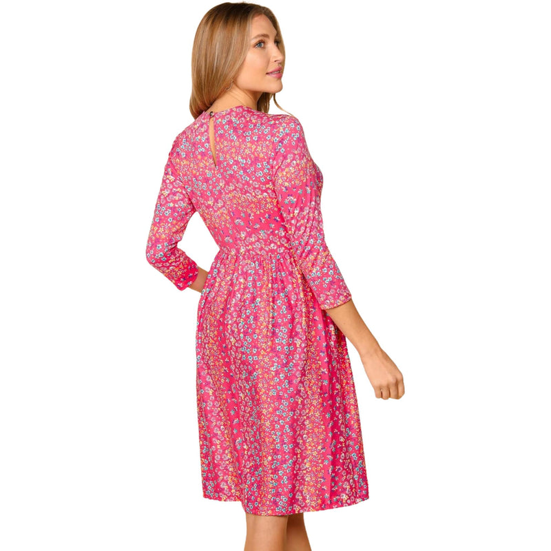 Load image into Gallery viewer, Back view of a woman in a pink floral dress with three-quarter sleeves, showing the dress&#39;s fit and back design.
