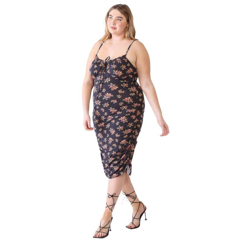 Load image into Gallery viewer, Plus-size model in a black floral ruched cami dress with spaghetti straps, walking confidently in lace-up heels.
