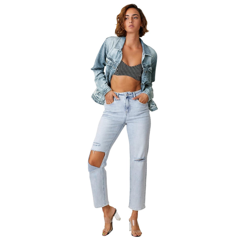 Load image into Gallery viewer, Woman wearing a button-up ombre washed denim jacket paired with light-wash distressed jeans and a striped crop top, posing confidently with hands in pockets.
