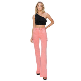 Front view of a woman in pink high-rise bootcut cargo jeans with side slits and a black one-shoulder crop top.