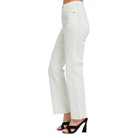 Side view of high-rise white straight-leg jeans, showcasing the clean lines and raw hem detail, paired with black heels.